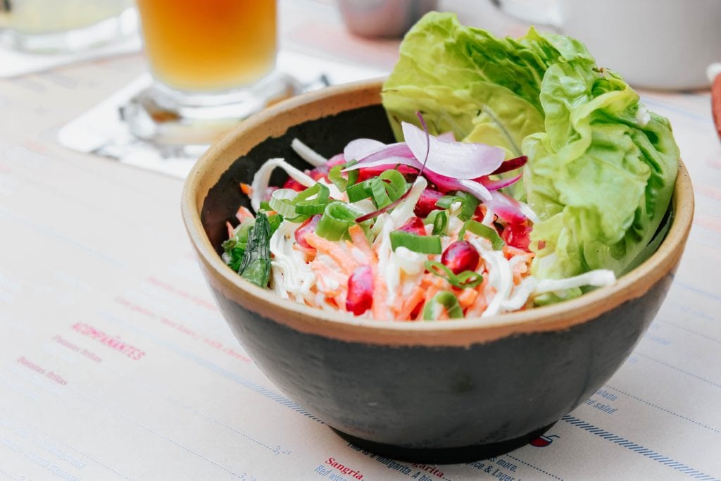 brown bowl containing lettuce and other colourful salad items