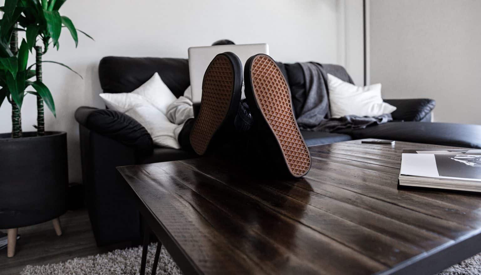 person looking at laptop with feet on table