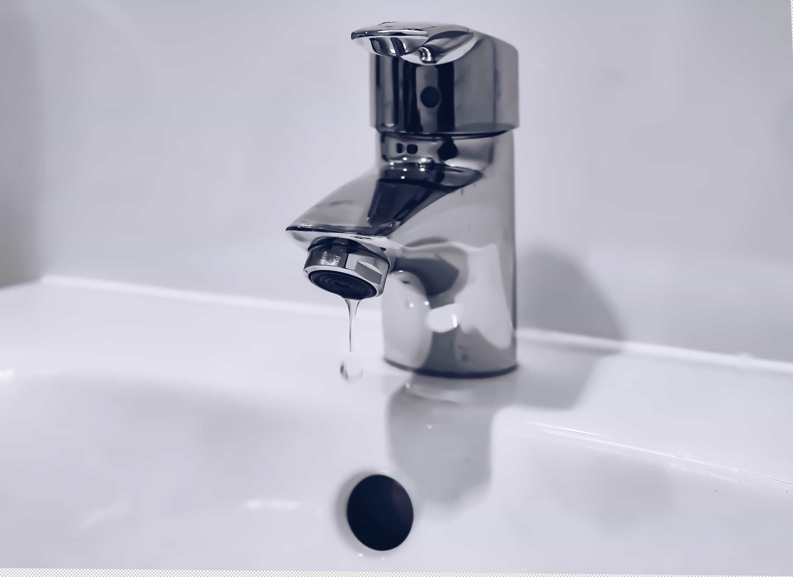 silver tap dripping water into white sink