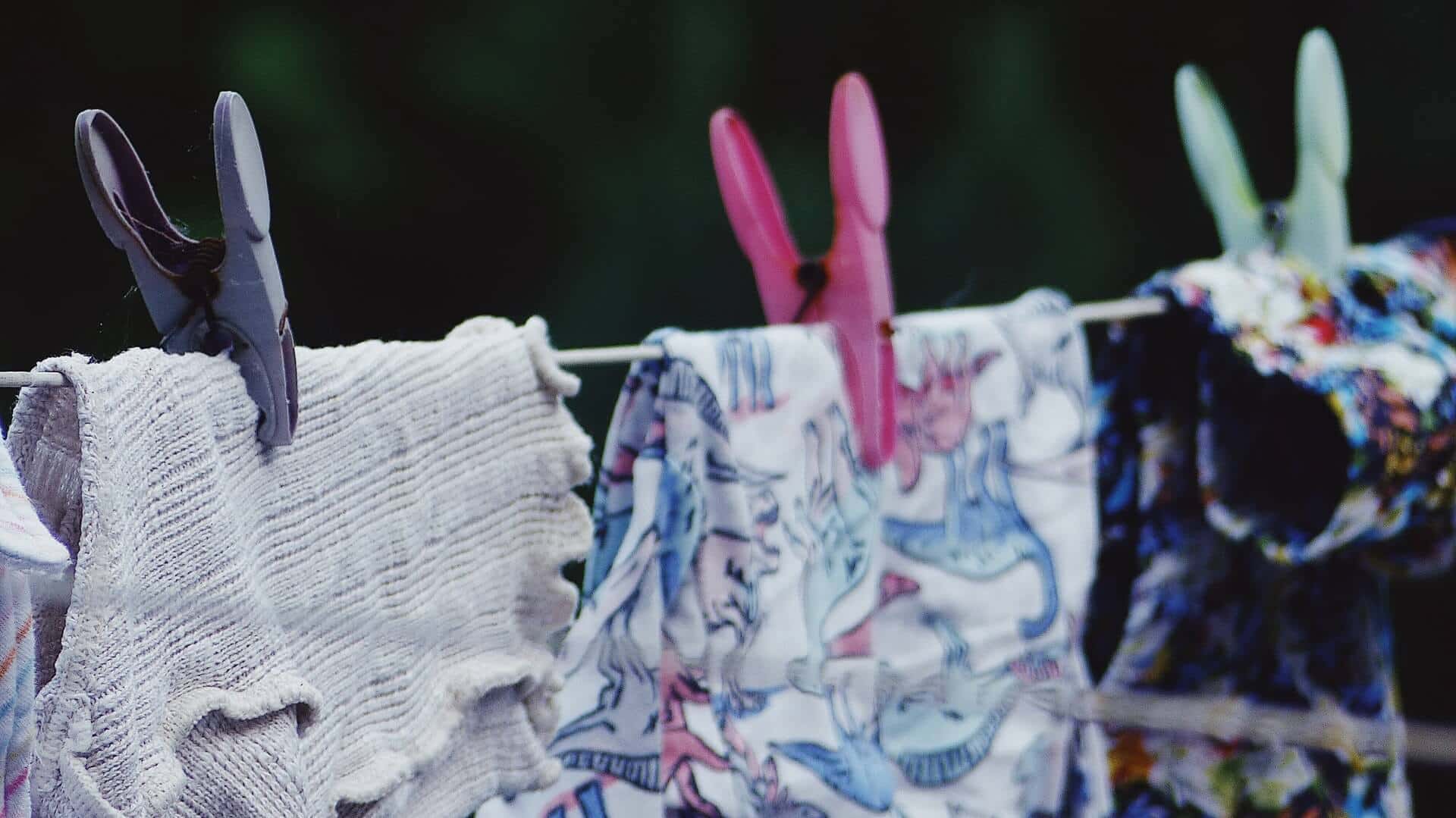 3 items of clothing on a washing line with purple, pink and green pegs. water saving tips