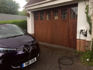 renault Zoe charging at home in front of brown garage door