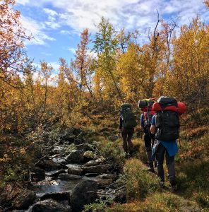 A group walking in single file next to a river