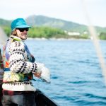 Friluftsliv - young man in a NOrdic-style sweater on a boat