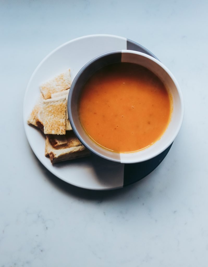 butternut squash soup in a bowl with toast on the side