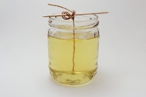 wick tied around lolly stick to secure it in place on DIY soy wax candle