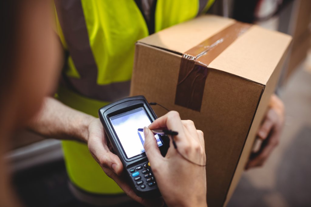 Someone signing on device for delivery