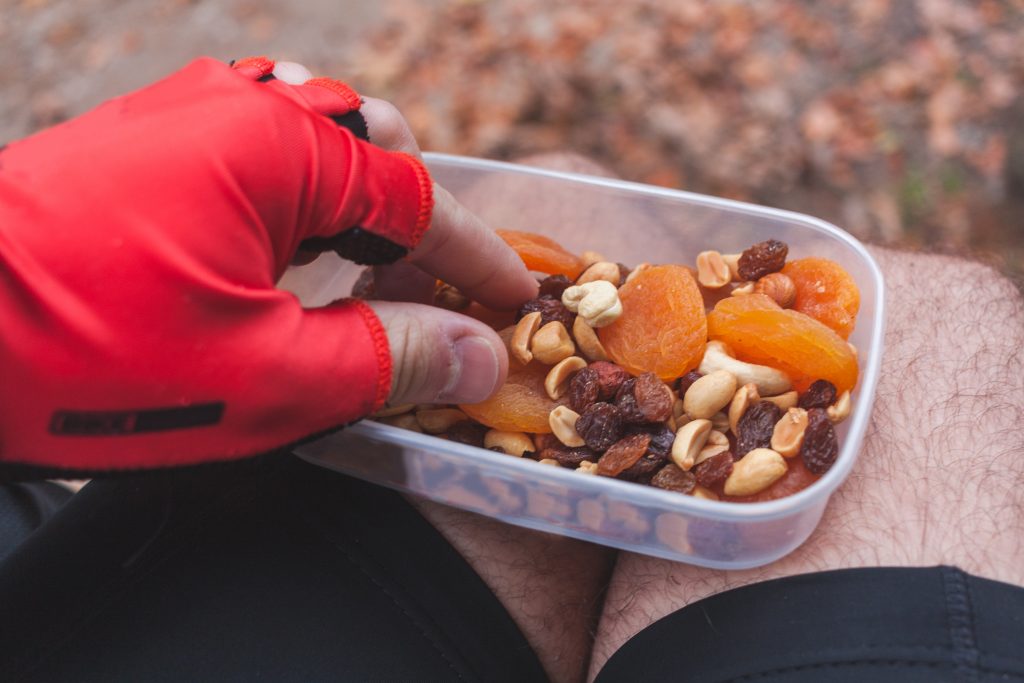 someone eating a box of snacks wearing bike gear